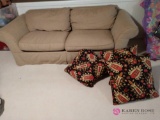 90 inch couch with pillows in basement