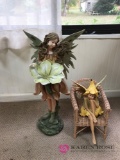 Two fairy figurines one on wicker chair