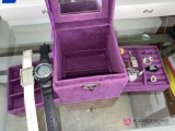 In office, purple jewelry box with rings, pins, watches.