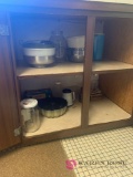 Contents of kitchen shelf right side of sink metal bowls strainers and miscellaneous