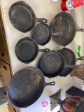 Seven cast iron pans in rec room