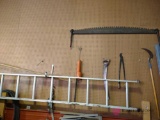 Items on wall in picture including ladder, two man saw, and miscellaneous tools
