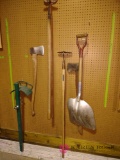 Assortment of yard tools including Acts, shovel, garden hose holder and more