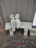 Concrete bench with figures.