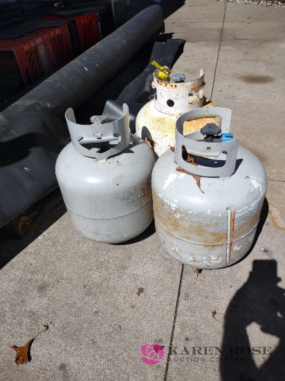 three 20 lb propane tanks