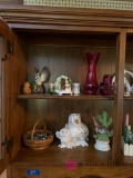 Two shelves of knickknacks in kitchen cabinet