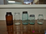 five canning jars including one Amber