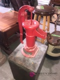 Antique water pump displayed on block of wood