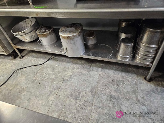 Eighty two inch stainless table with contents on bottom shelf only
