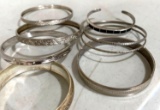 eight silver colored bangle bracelets