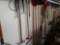 Yard tool lot including shovels, rakes, and more hanging on back wall of the garage
