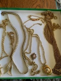 7Gold colored necklaces with pennants