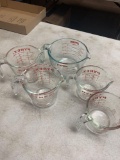 Five Pyrex measuring cups