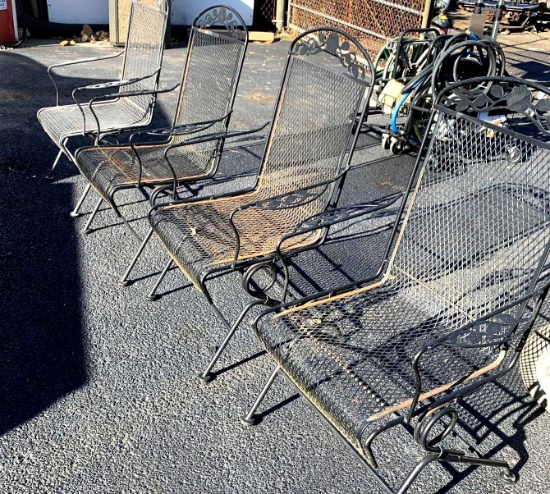 Four matching black metal patio chairs