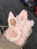 Vintage celluloid face doll on pillow