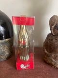 collectible gold Coca-Cola bottle. (upstairs)