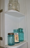LOT OF BALL JARS ON SHELVES BY SINK
