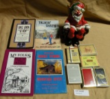 4 PAPERBACK STORY/JOKE BOOKS, PLAYING CARDS, CLOWN SANTA FIGURE