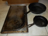 Two cast iron skillets and griddle