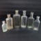 Six clear old medicine bottles, liniment and sample, 3