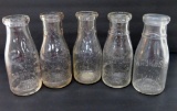 Five Waukesha embossed milk bottles, quart