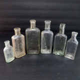 Six clear old medicine bottles, liniment and sample, 3