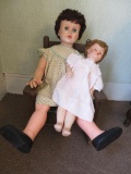 Two vintage dolls and wooden child size rocking chair