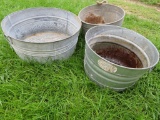 Three galvanized tubs and bushels, some rust noted