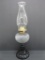 Black glass base oil lamp with swirl font, 18