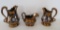 Three Copper Lustre Pitchers, floral painted designs