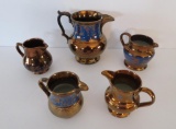 Five copper lustre vintage pitchers