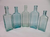 Five aqua medicine bottles