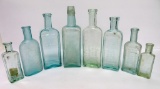 Eight green and aqua medicine bottles, 3 3/4