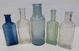 Five extract bottles, blue, green and clear, 4 1/2