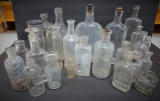 A large assortment of clear bottles, medicine, liniment, liquor and ointment