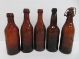 Five amber Milwaukee beer bottles, applied lip and blob top