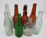 Eight assorted beer, soda and liquor bottles