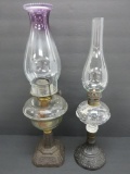 Two ornate metal base oil lamps, 17
