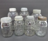 Seven clear glass jars, 1/2 gallon and quarts, all different makers