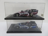 Two Skoal model race cars, one case is signed by