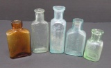 Five vintage medicine bottles, green, aqua and amber