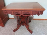 Ornate heavily carved walnut parlor table