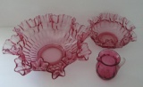 Three pieces of cranberry glass, ruffled bowls and hand blown creamer