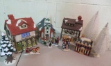 Four Christmas houses, figures and bottle brush trees