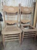 Two ornate unfinished press back chairs, one with cane seat