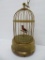 Mechanical singing bird in ornate metal cage, 11