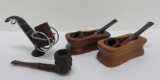 Four vintage pipes and three pipe holders