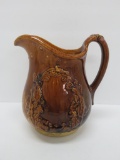 Rockingham Bennington Style milk pitcher with wreath design, 9 1/2