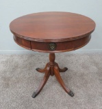 Round mahogany table with drawer, metal cap feet