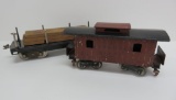 Two Lionel train car, caboose and flat car with wood hauling